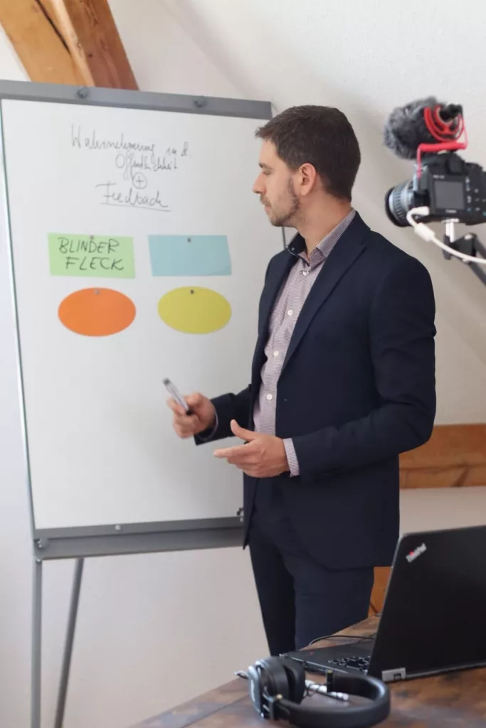 Marek Zalarski hält eine Präsentation am Whiteboard und erklärt das Konzept des blinden Flecks im Supervision Session.